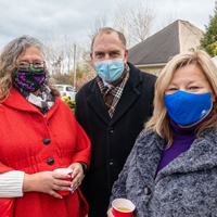 Three representatives posing for photo outside with masks on