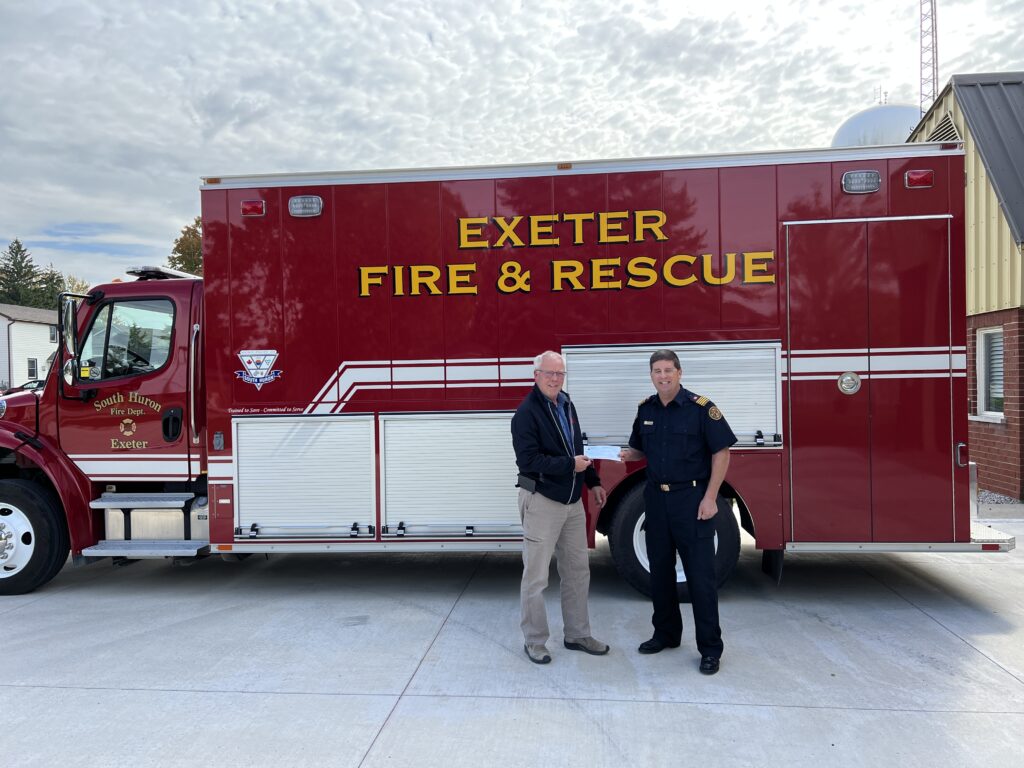 Loss prevention officer and fire safety officer posing for picture in-front of fire rescue vehicle.